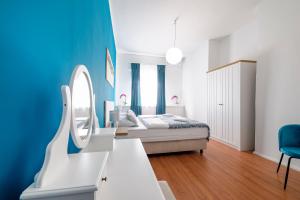 a bedroom with a bed and a blue wall at Hostel Globo in Šibenik