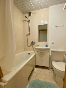 een badkamer met een bad, een toilet en een wastafel bij Studlendas in Klaipėda