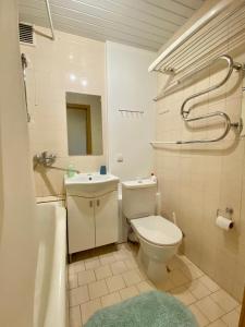 een badkamer met een toilet, een wastafel en een bad bij Studlendas in Klaipėda