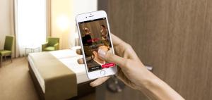 a person taking a picture of a hotel room with their cell phone at IntercityHotel Kassel in Kassel