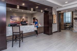 une femme debout au comptoir dans le hall de l'hôtel dans l'établissement Staybridge Suites Charleston - Mount Pleasant, an IHG Hotel, à Charleston