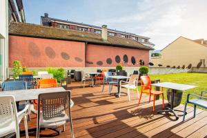 une terrasse avec des tables et des chaises dans un bâtiment dans l'établissement ibis Delémont, à Delémont