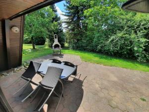 - une table de pique-nique et 2 chaises sur la terrasse dans l'établissement Ferienhaus Winnetou 114, à Waldbrunn