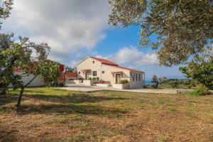 a white house with a red roof at Georgia Villas in Skiathos