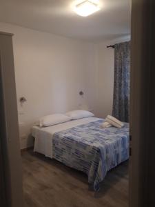 a bedroom with a bed with a blue and white blanket at Cuor di leone guest house in Favignana