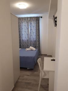 a small room with a bed and a table and chair at Cuor di leone guest house in Favignana