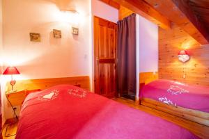 a bedroom with a red bed in a cabin at Chalet Le Mélézin hameau des Chazals Nevache Hautes Alpes in Névache +21 photos