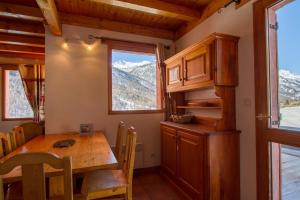 een eetkamer met een tafel en een raam bij Chalet Le Mélézin hameau des Chazals Nevache Hautes Alpes in Névache