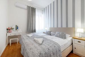 a white bedroom with a bed and a window at Hostel Globo in Šibenik