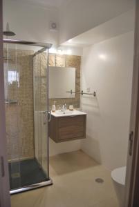 W łazience znajduje się prysznic, umywalka i lustro. w obiekcie Casa dos Primos w mieście Muxagata