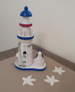 a toy lighthouse with a penguin on the floor at Casa Ely in Sottomarina