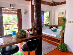 a room with a bed and a table with a glass of wine at Apo Diver Beach Resort in San Juan