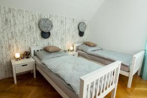 1 Schlafzimmer mit 2 Betten und 2 Nachttischen in der Unterkunft L&P Appartement Klagenfurt in Klagenfurt am Wörthersee