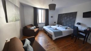 1 dormitorio con cama, sofá y escritorio en Hotel Restaurant La Calade, en Octon