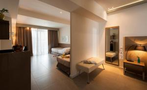 a hotel room with a bed and a mirror at Ostria Sea Side Hotel in Hanioti