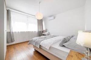 a white bedroom with a bed and a window at Hostel Globo in Šibenik