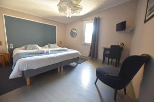 a bedroom with a bed and a chair and a desk at Hotel Restaurant La Calade in Octon