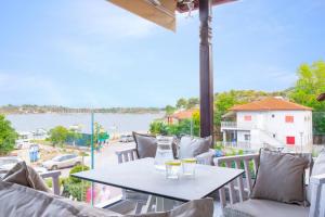 een tafel en stoelen op een balkon met uitzicht op het water bij Ormos Luxury Suites Ammos in Ormos Panagias