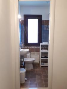 a bathroom with a sink and a toilet and a window at Cuor di leone guest house in Favignana