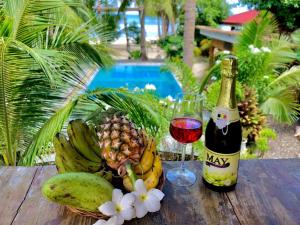 Apo Diver Beach Resort في سان خوان: زجاجة من النبيذ وسلة من الفواكه على الطاولة