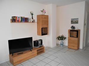 a living room with a flat screen tv on a wooden entertainment center at Ferienwohnung Gisela Rohde in Bad Bramstedt