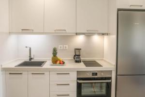 a kitchen with white cabinets and a counter top with a pineapple at Georgia Villas in Skiathos +37 photos