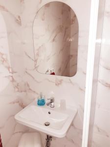 bagno bianco con lavandino e specchio di Black Gold Private Room a Msida