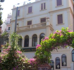 a building with pink flowers in front of it at Jonic Hotel Mazzar&ograve; in Taormina