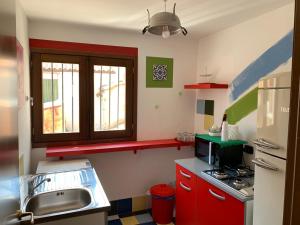 a small kitchen with red cabinets and a sink at Cialoma B&B in Palermo +73 photos