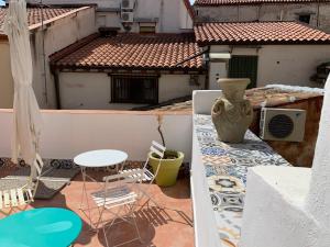 a balcony with a table and chairs and a vase at Cialoma B&B in Palermo
