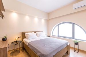 um quarto com uma cama e uma janela arqueada em Urban Lofts em Corfu Town
