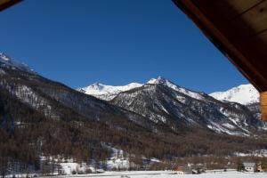 - une vue sur une chaîne de montagnes avec des montagnes enneigées dans l'établissement Le Queyrellin hameau des Chazals Nevache Hautes Alpes, à Névache