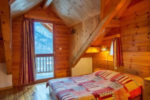- une chambre avec un lit et une grande fenêtre dans l'établissement Le Queyrellin hameau des Chazals Nevache Hautes Alpes, à Névache