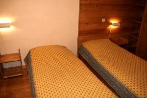 two beds in a room with wooden walls at Le Gouroùn Hameau des Chazals Nevache Hautes Alpes in Névache +17 photos
