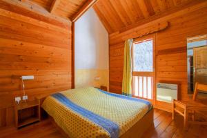 - une chambre avec un lit dans une pièce en bois dans l'établissement Le Gouroùn Hameau des Chazals Nevache Hautes Alpes, à Névache