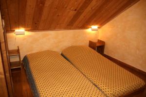 a bedroom with two beds with lights on the wall at Le Gouroùn Hameau des Chazals Nevache Hautes Alpes in Névache