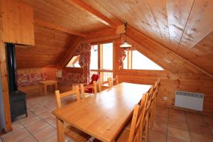 a dining room with a wooden table in a cabin at Le Sorè Hameau des Chazals Nevache Hautes Alpes in Névache