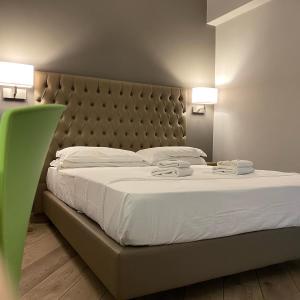 a bedroom with a large white bed with a padded headboard at Hotel Genziana in Genova