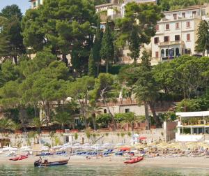 タオルミーナにあるジョニッチ オテル マッツァロの海上のボートがたくさんあるビーチ