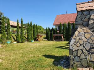 a yard with a picnic table and a stone wall at Casa Carpati in Zărneşti