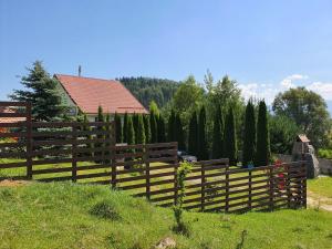 a wooden fence in front of a house at Casa Carpati in Zărneşti