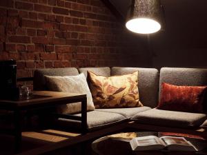 a living room with a couch and a brick wall at Gastwerk Hotel Hamburg in Hamburg