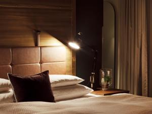 a bedroom with a bed with a headboard and a lamp at Gastwerk Hotel Hamburg in Hamburg
