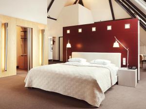 a bedroom with a large white bed with a red headboard at Gastwerk Hotel Hamburg in Hamburg