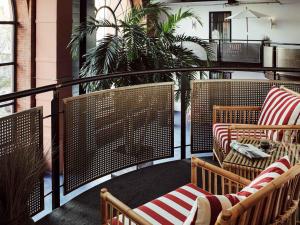 a balcony with wicker chairs and a table at Gastwerk Hotel Hamburg in Hamburg