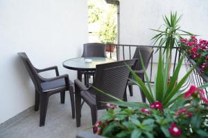 a patio with chairs and a table and some plants at Apartments Ajla in Mostar