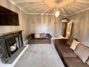a living room with a couch and a fireplace at Flatts farm, Yorkshire dales home in Skipton