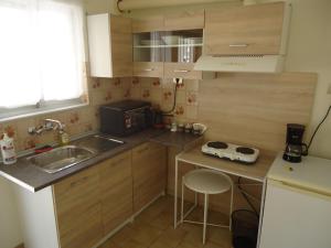 a small kitchen with wooden cabinets and a sink at Original House in Larisa