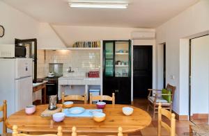a kitchen and dining room with a wooden table at Can Nigg in Playa Migjorn +13 photos