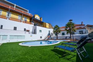 a patio with two chairs and a pool in a yard at O Paço - Exclusive Accommodation in Tomar
